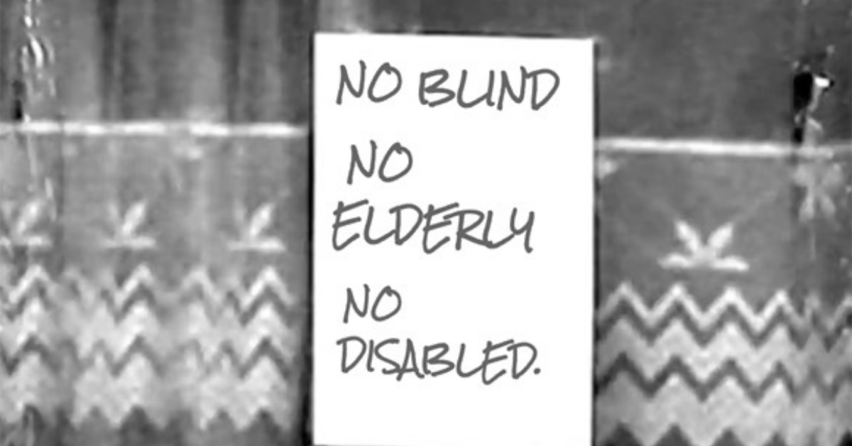 Window with a sign saying “No Blind, No Elderly, No Disabled